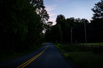 Countryside rural paved road in Lyndhurst, Virginia at evening dark night sunset with fence at Longstaff lane and Reeds gap road in mountains