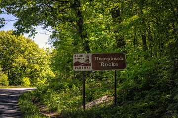Car point of view on blue sky mountains parkway in Virginia summer with sign for Humpback rocks...