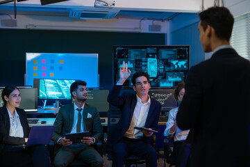 Group of professionals businessman and businesswoman in formal attire discussing ideas on innovative technology development project with tablets and laptops in dark modern office