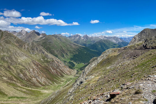 High alpine scenic view from Timmelsjoch on the Austria&ndash;Italy border, looking southeast towards Passeier Valley; rocky slopes, green valley and clear sky