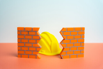 A construction worker's hard hat in a wall crack. Architectural repair and demolition service....
