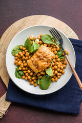 Pan-seared cod served with chickpeas and fresh spinach on a white plate