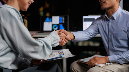 Business partners making a deal, shaking hands in a meeting, finalizing a partnership in a modern office setup