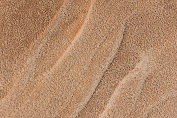 A close-up of wind blown reddish brown sand that forms abstract patterns in southern Utah, USA