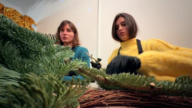 caucasian partners crafting large holiday wreath together