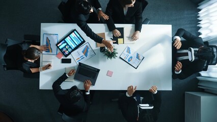 Top view of smart project manager use vr headset while business team discuss about marketing plan by using stock market graph from tablet and send data to virtual world. Technology. Directorate.