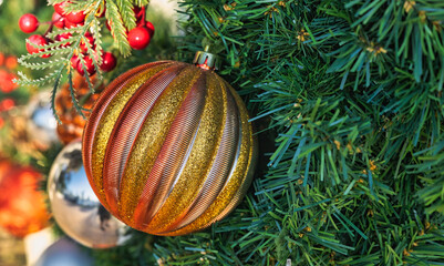 025-12-01 A BRONZE AND GOLD COLORED CHRISTMAS ORNAMENT HANGING ON A TREE BRANCH WITH A SOFT FADED BACKGROUND AND NICE TEXTURE