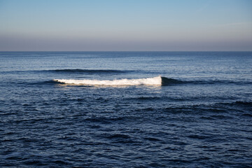 2025-12-01 WAVES COMING ON SHORE IN LA JOLLA CALIFORNIA IN THE MORNING WITH THE WHITE CAP HIGHLIGHTED BY THE MORNING SUN