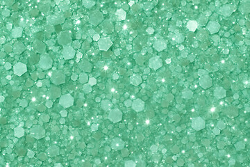 Macro close up of teal green glitter texture with hexagonal sequins and sparkling light effects