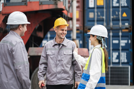 Happy engineer and worker team working in logistic terminal of container cargo, Diverse construction team in safety gear outdoors	