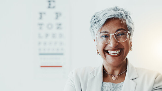 Mature woman, optometrist and portrait at clinic with smile, glasses and chart for eyesight assessment. Person, optician and happy with pride, confidence and eye care services for vision in Mexico