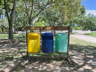 Three Colorful Recycling Bins for Plastic, Paper, and Glass in Park Environment