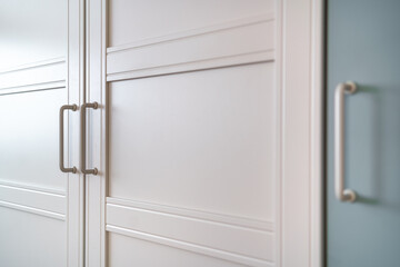 Fototapeta premium Białe drzwi szafki, szafy z uchwytami w nowoczesnym wnętrzu