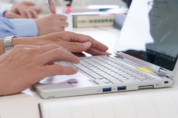 会議室でノートパソコンを操作する若い男性の手元