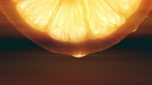 Lemon slice drop juice backlit illuminating macro