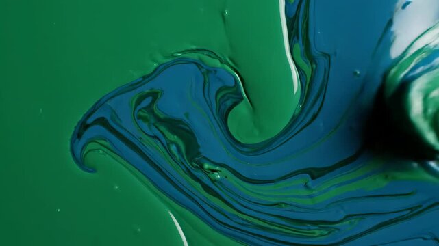Seamless loop of vibrant emerald green and deep cyan liquid inks swirling slowly and blending together in an amorphous abstract background smooth, motion graphics, flow