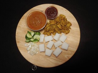 Top-down shot of Grilled Stickless Chicken Satay served with Rice Cakes, Sambal and Peanut Sauce