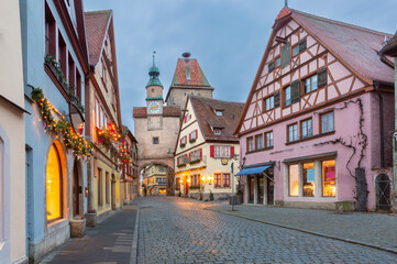 Fototapeta premium Roeder Arch and Markus Tower in Rothenburg ob der Tauber Germany at dawn with holiday lights