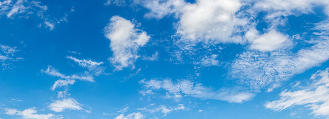 blue sky covered with scattered white clouds of various shapes and sizes creating a spacious, clean and bright nature background