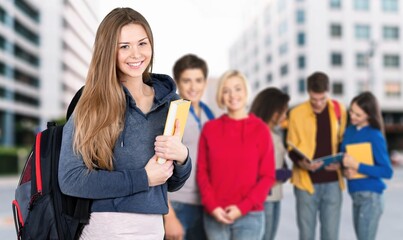 Happy young student girl at the university with friends