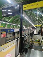 Busy Subway Station Platform with Escalator and Information Display, Reflecting Commuting and...