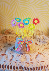 A crochet basket made from colorful jute with flowers