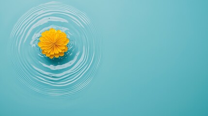 A vibrant yellow flower floats on calm turquoise water, creating gentle ripples that enhance the serene atmosphere.