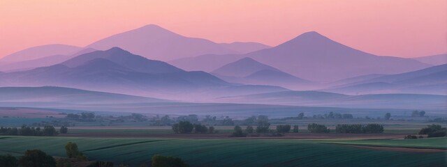Layered mountain range at sunrise with pink sky