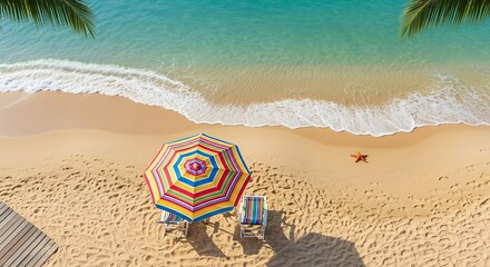 Obraz premium Aerial top down view of a colorful beach umbrella on a sandy tropical shore.