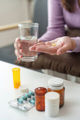 Health Management. Individual preparing to take medication with water for wellness.