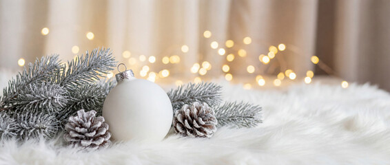 Christmas white decoration ball and spruce tree close up, bokeh lights background. Merry Christmas and Happy Holidays greeting card, frame, banner. New Year. Noel. Winter festive xmas theme