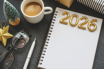 Festive 2026 New Year planning concept with a blank notebook coffee and decorations on a dark surface perfect for setting goals