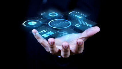 Close up of a human hand holding a glowing futuristic holographic interface with digital data and abstract glowing circles against a dark background