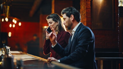 Elegant couple arriving restaurant together closeup. Lady talking mobile device