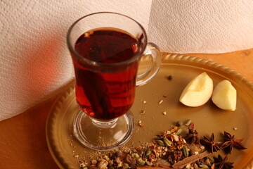 Warm Red Tea In Glass Mug With Apple Slices And Spices On A Plate