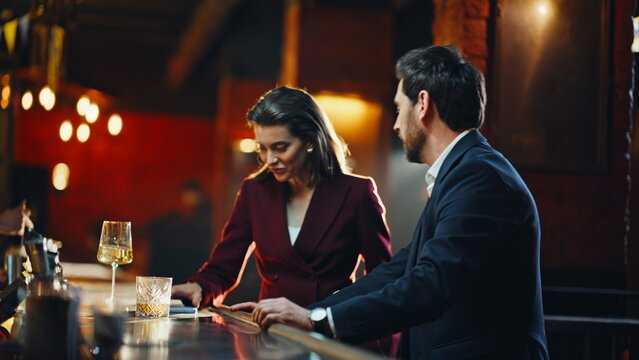 Smiling partners chatting bar lounge closeup. Relaxed coworkers enjoying drinks