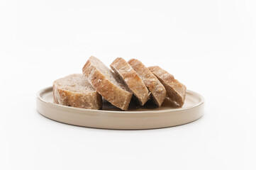 fette di pane naturale su un vassoio circolare in terracotta, sfondo bianco