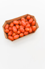 contenitore in cartone con pomodori varit&agrave; datterino su uno sfondo bianco