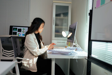 Woman working on computer in modern office with sunlight