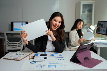 Asian businesswoman holding blank sign with happy expression