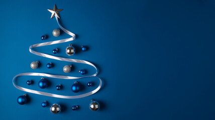 Creative Christmas tree made of ribbon and ornaments silver and blue decorations on a dark blue background holiday season concept