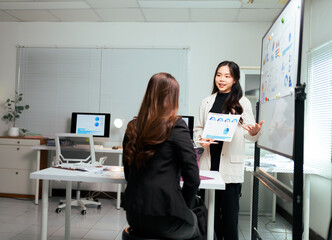 Businesswoman presenting data analysis charts to coworker in office