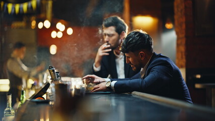 Drunken people resting pub smoking cigarettes in golden light lounge closeup