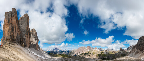 Panorama in the Dolomites, Italy with Tre Cime di Lavaredo, Crep Checio (Hohe Gaisl), Rautkofel and Monte Paterno (from left to right); pale limestone towers above scree against blue sky with clouds