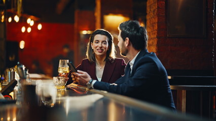 Man woman drinking alcohol sitting modern evening pub counter using smartphone