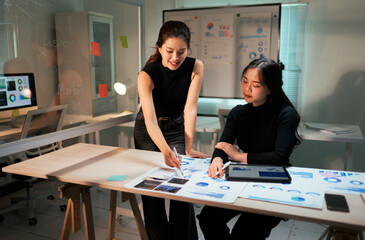 Marketing businesswomen analyzing data charts for strategy planning