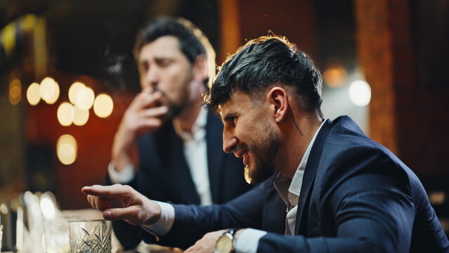 Buzzed visitors chilling bar sharing cigarette exchanging jokes indoors closeup - Powered by Adobe