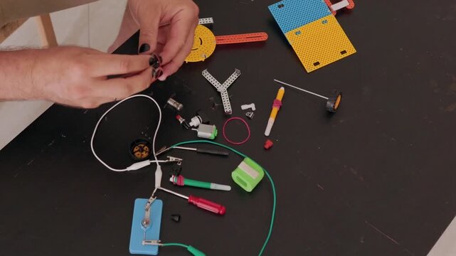 Person assembling educational robotics kit on a table