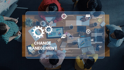 A team collaborates in a modern office setting, discussing change management strategies while analyzing data, showcasing teamwork and innovation in action. Trope