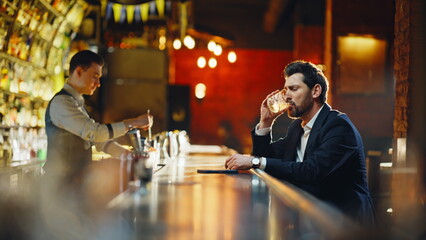 Drunk man sipping alcohol sitting bar counter closeup. Relaxed guy paying waiter